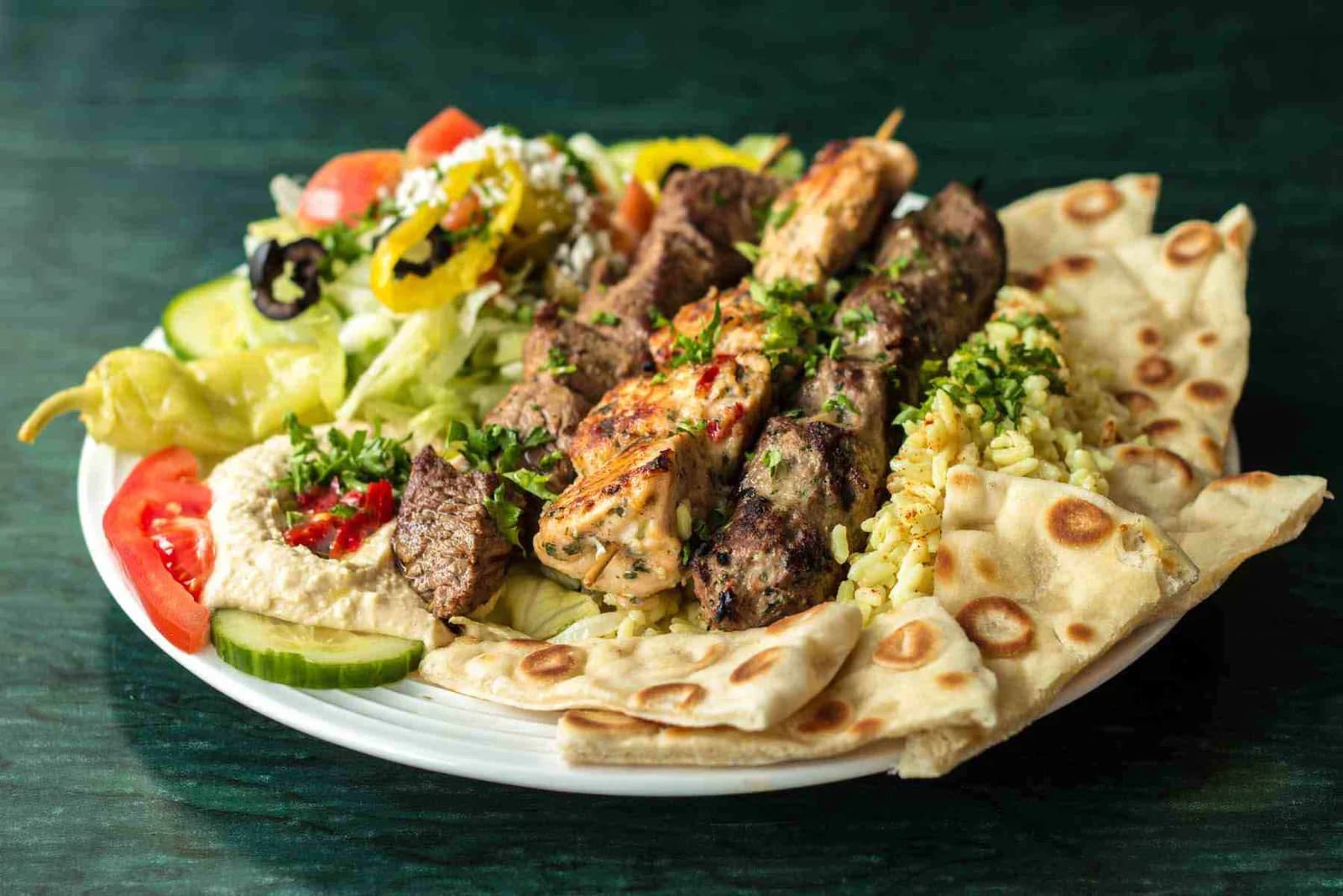 A Halal Pita mixed Mediterranean grill with kebabs, salad and warm pita